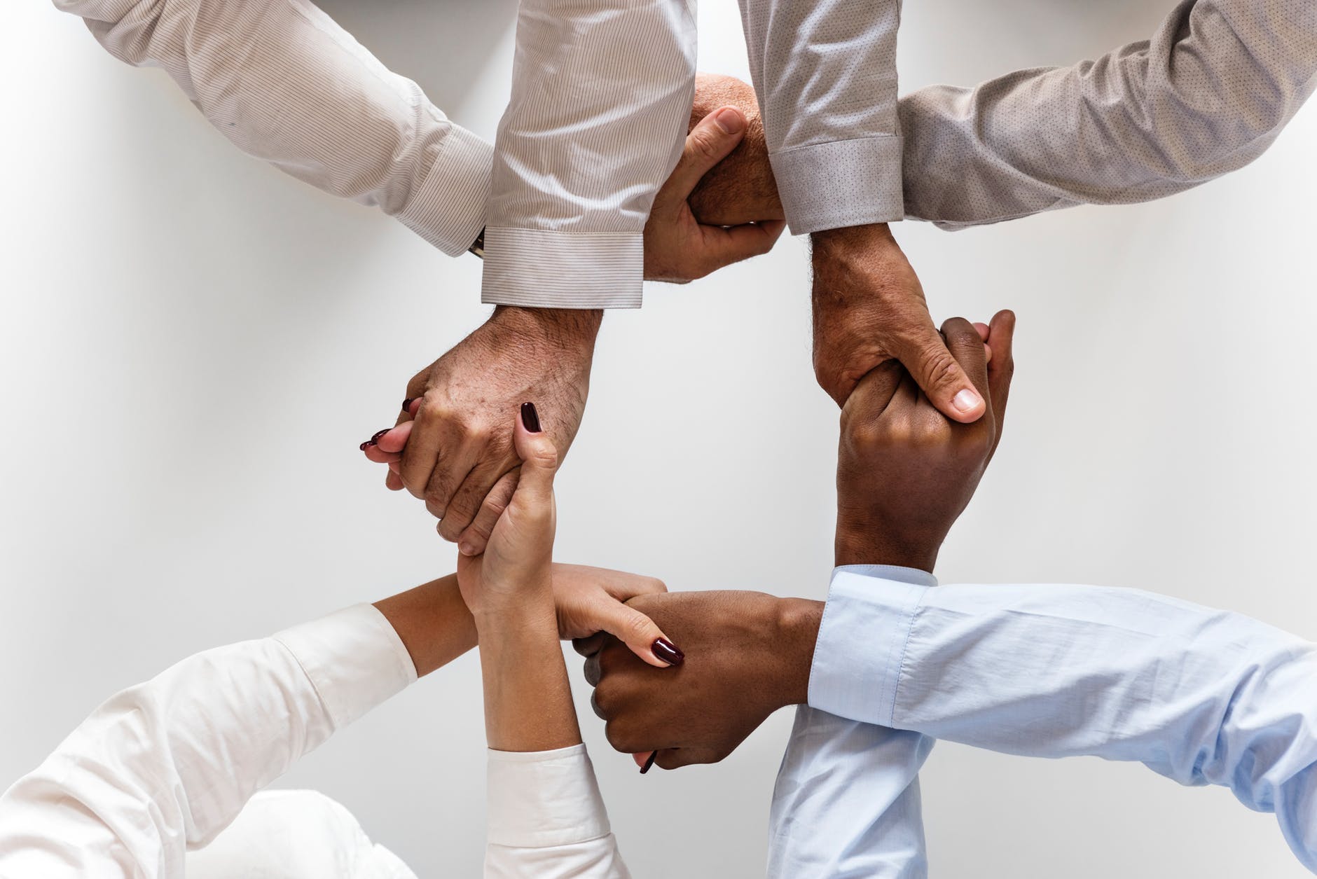 photo of four persons uniting hands